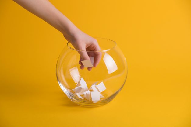 hand picking notes from glass bowl