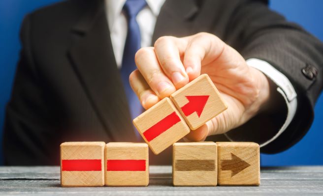 business man holding blocks with arrows