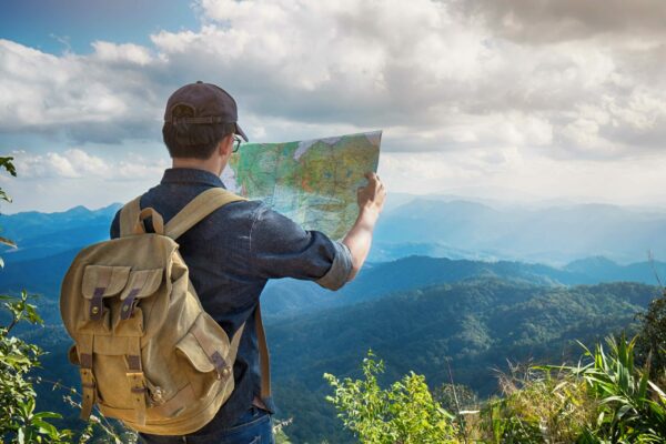 hiker looking at map over mountains