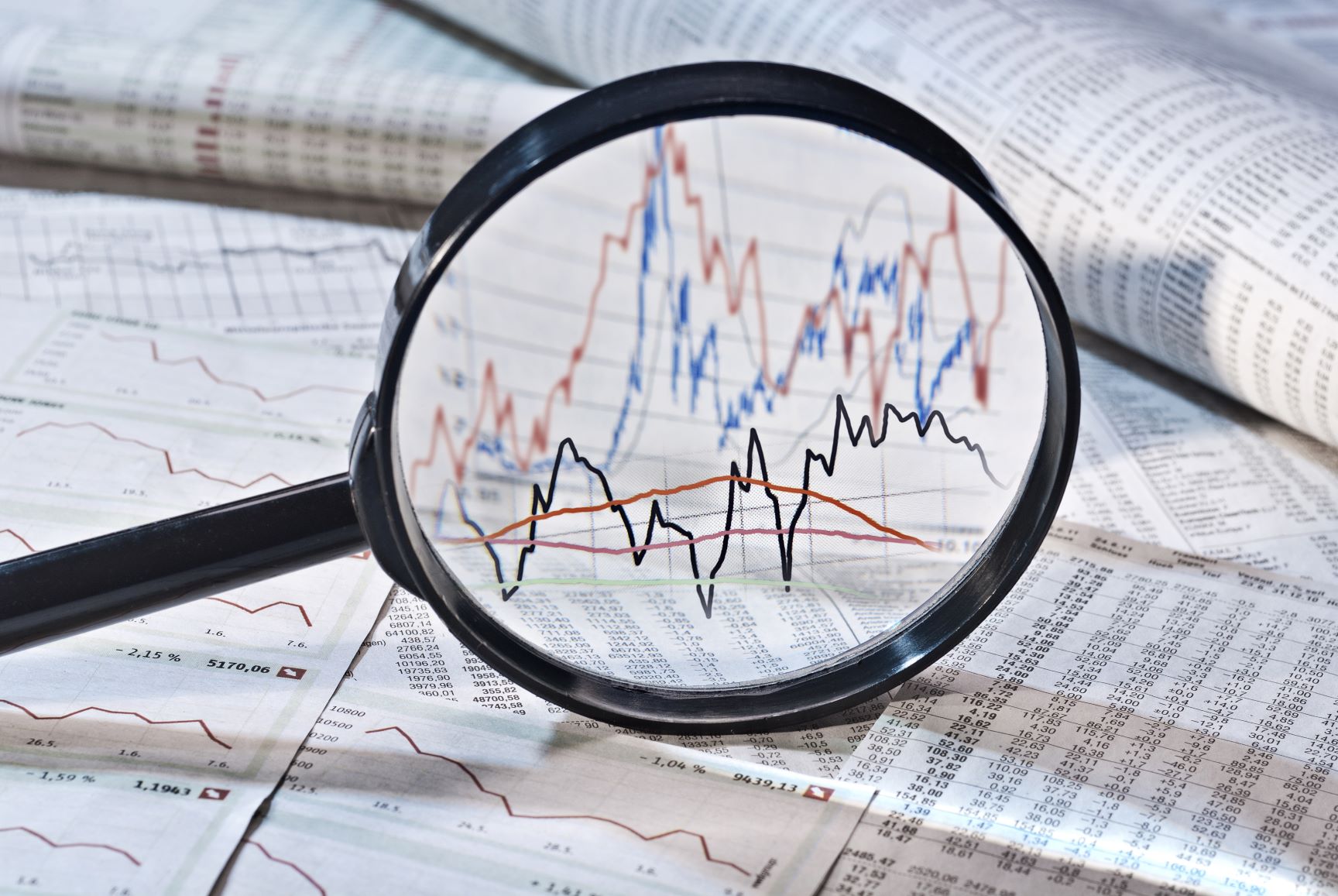 magnifying glass looking at charts